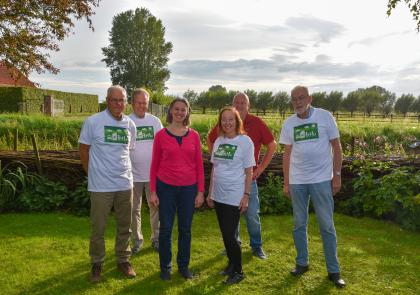 Foto van de werkgroepleden buiten gemaakt in een groene omgeving